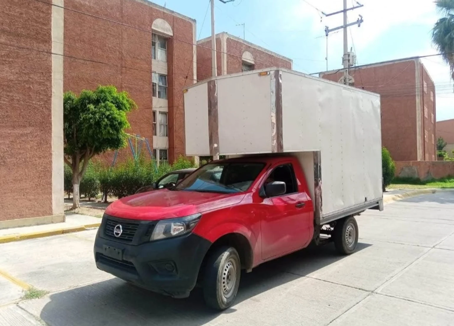 Camioneta Nissan roja con caja