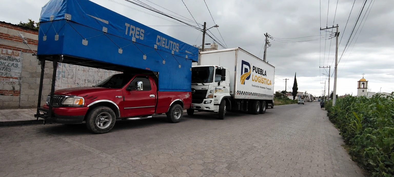 Camioneta roja y camión Puebla Logística en la misma ruta